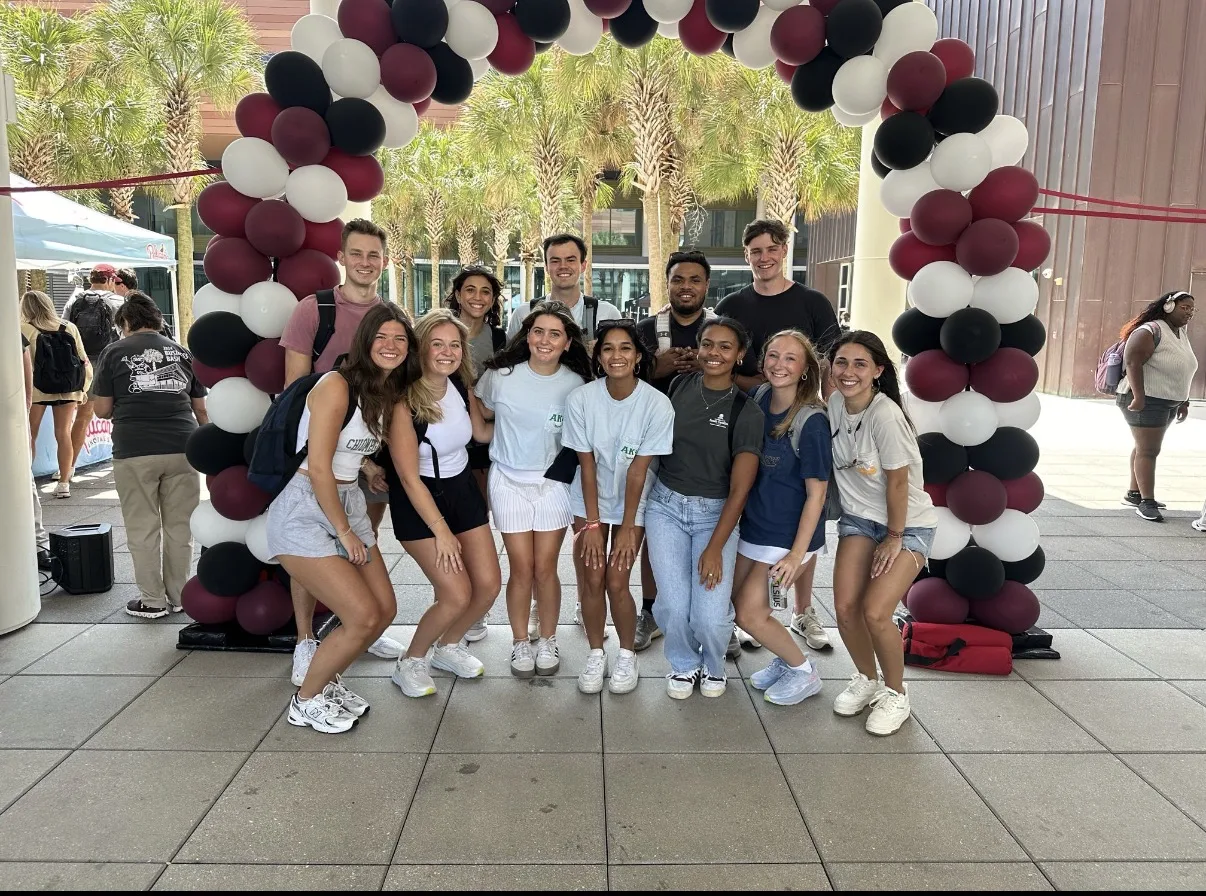 Brothers at the USC organization fair under a balloon arch